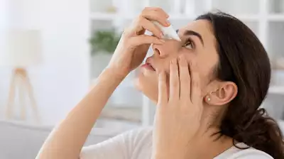 Lifestyle image showing a person using eye drops